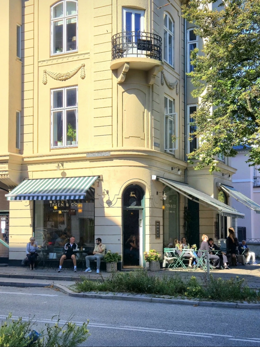 Café Ipsen & Co on the corner of Gammel Kongevej, Frederiksberg — awnings and pavement tables in the sun