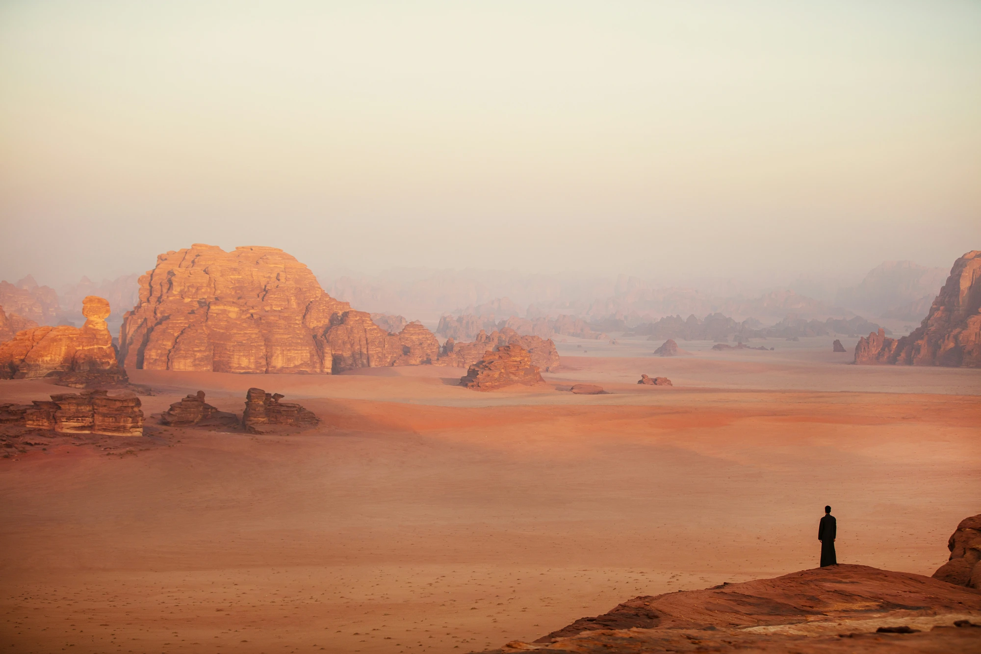 A lone figure standing in a vast desert at dusk, feeling lost and searching for the way forward.