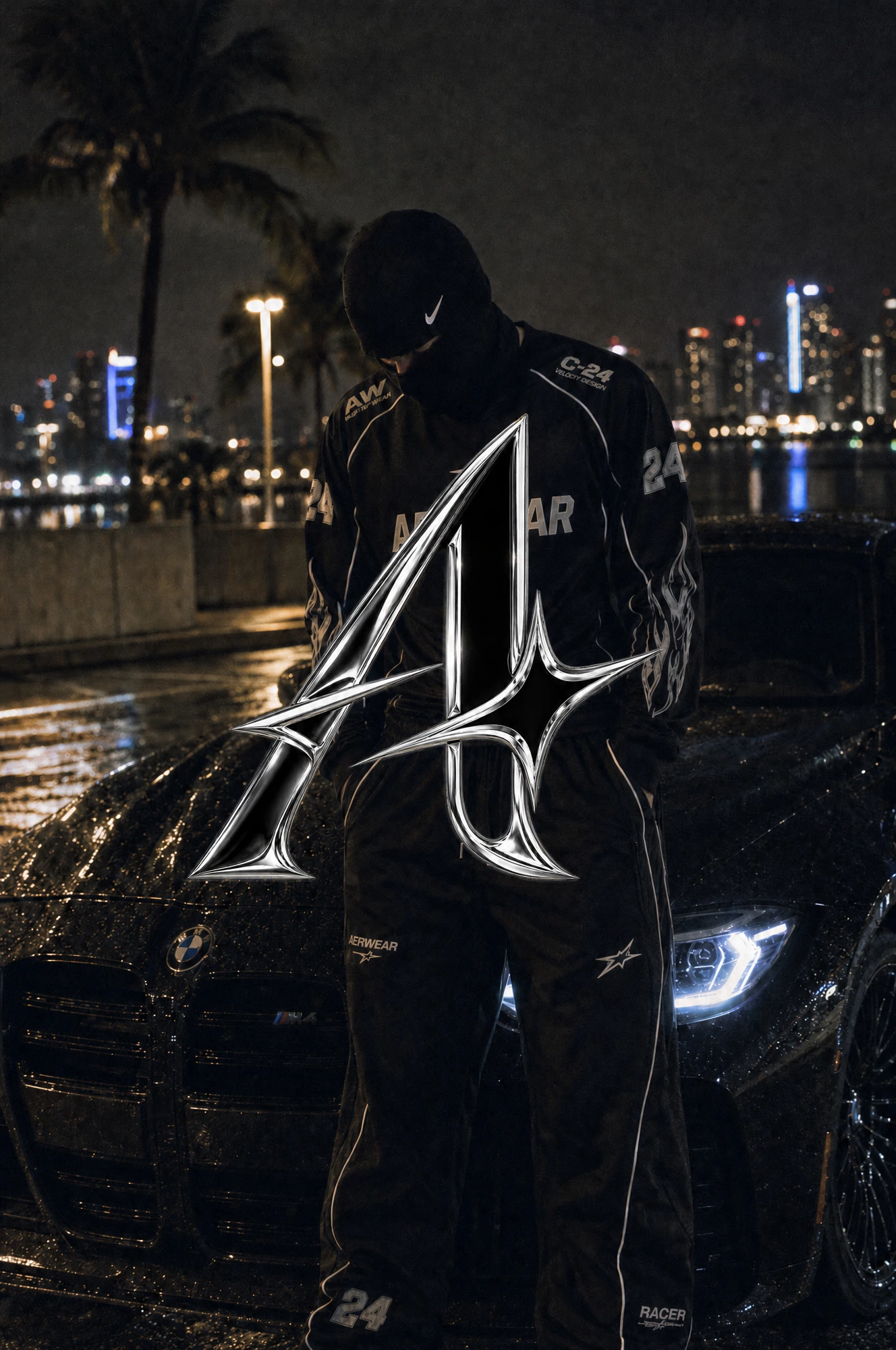 AERWEAR Racer jersey and track pants, model beside a BMW on a rainy Miami night.