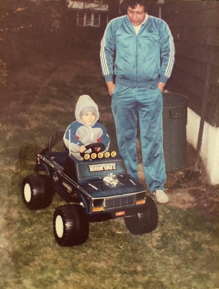 Young Greg in a Bigfoot RC monster truck with his dad