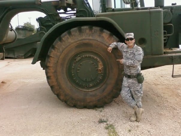 Greg in uniform next to a military vehicle