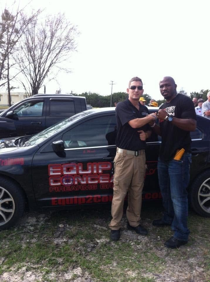 Greg with a colleague in front of the E2C branded car