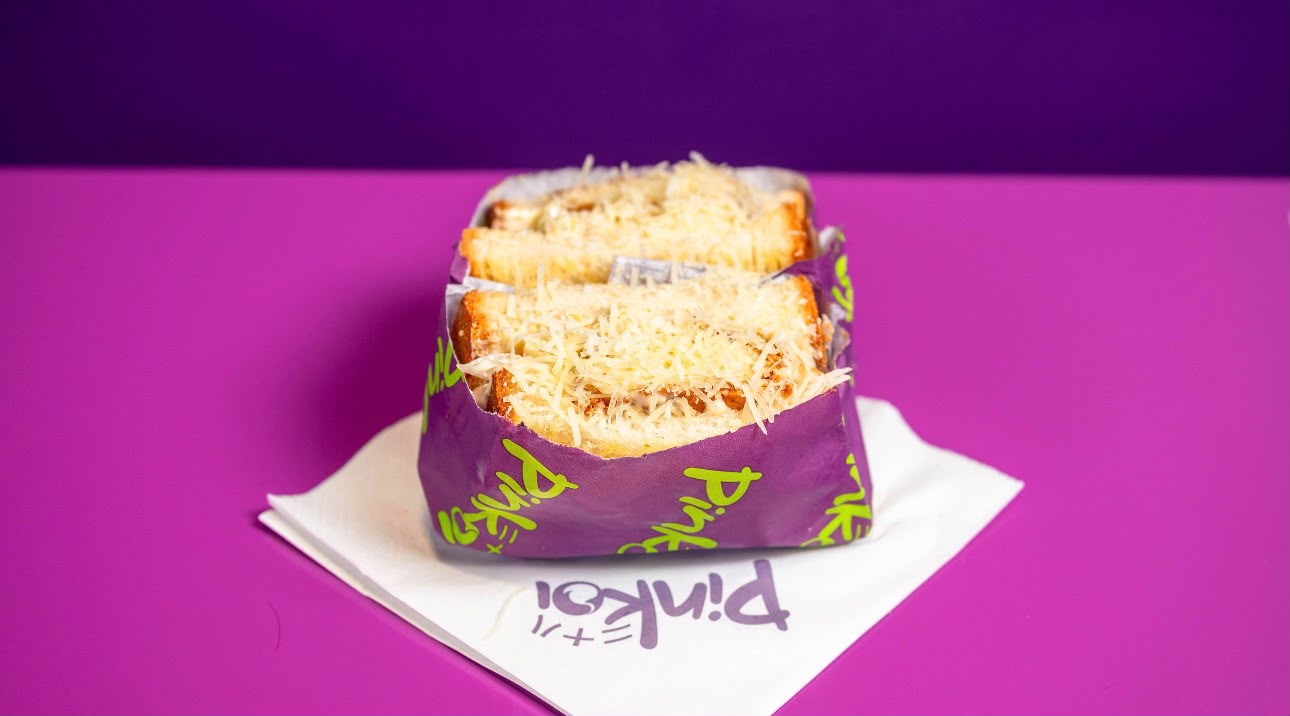 Caesar sando topped with shaved parmesan in Pinkoi wrap