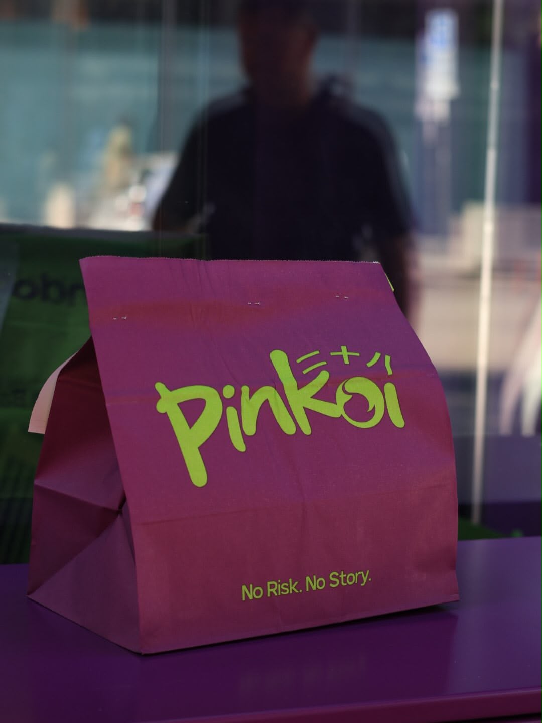 Pinkoi pink takeaway bag stamped with No Risk. No Story.