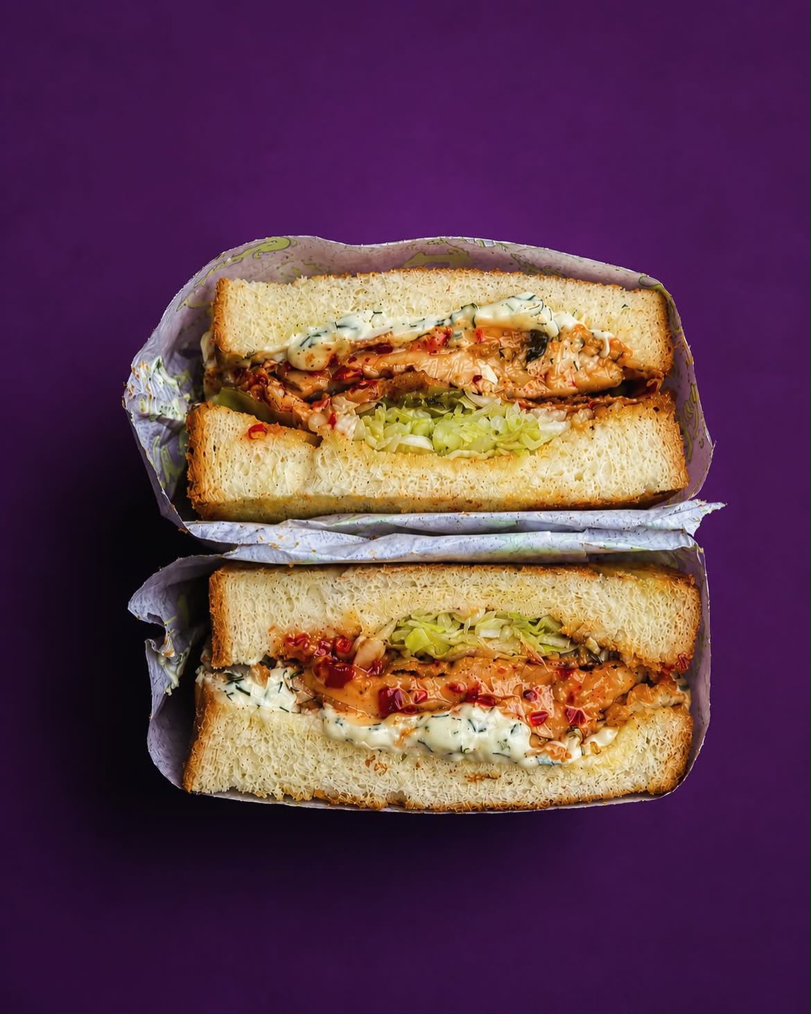 Double-stacked chicken sando with bang bang drizzle and crushed chillies