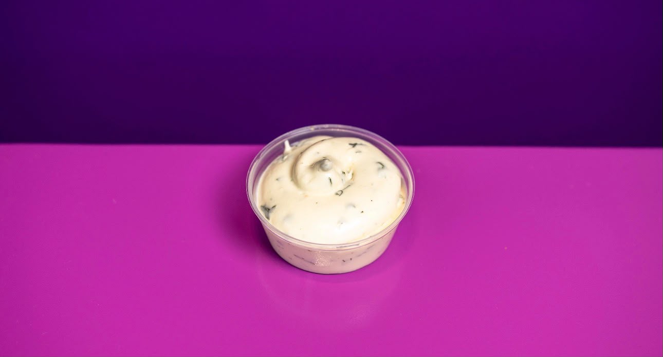 Cup of ranch sauce with herbs